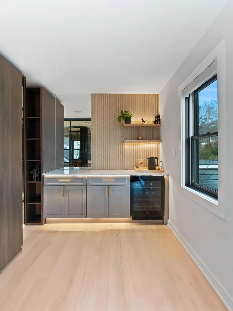 Remodeled coffee station with oak slat wall and custom cabinetry